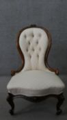 A Victorian walnut spoon back nursing chair, with a buttoned back, upholstered in patterned ivory