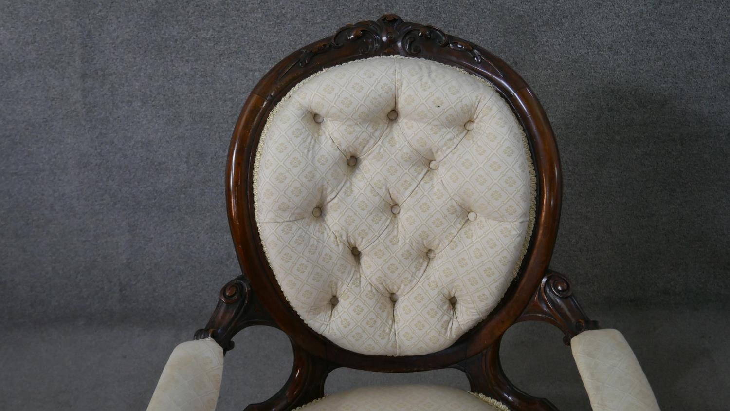 A Victorian walnut open armchair, upholstered in patterned ivory fabric, with an oval buttoned back, - Image 4 of 7