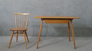 An Ercol elm dining table, the top with rounded corners, over a single drawer, on splayed legs,