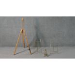 A collection of easels, including a pine artists easel, a baroque style brass easel and two other