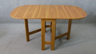 A mid to late 20th century drop leaf dining table, the top with rounded corners, on gate legs. H.