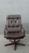 A mid century brown vinyl swivel lounge or desk chair with button detailing on a five star