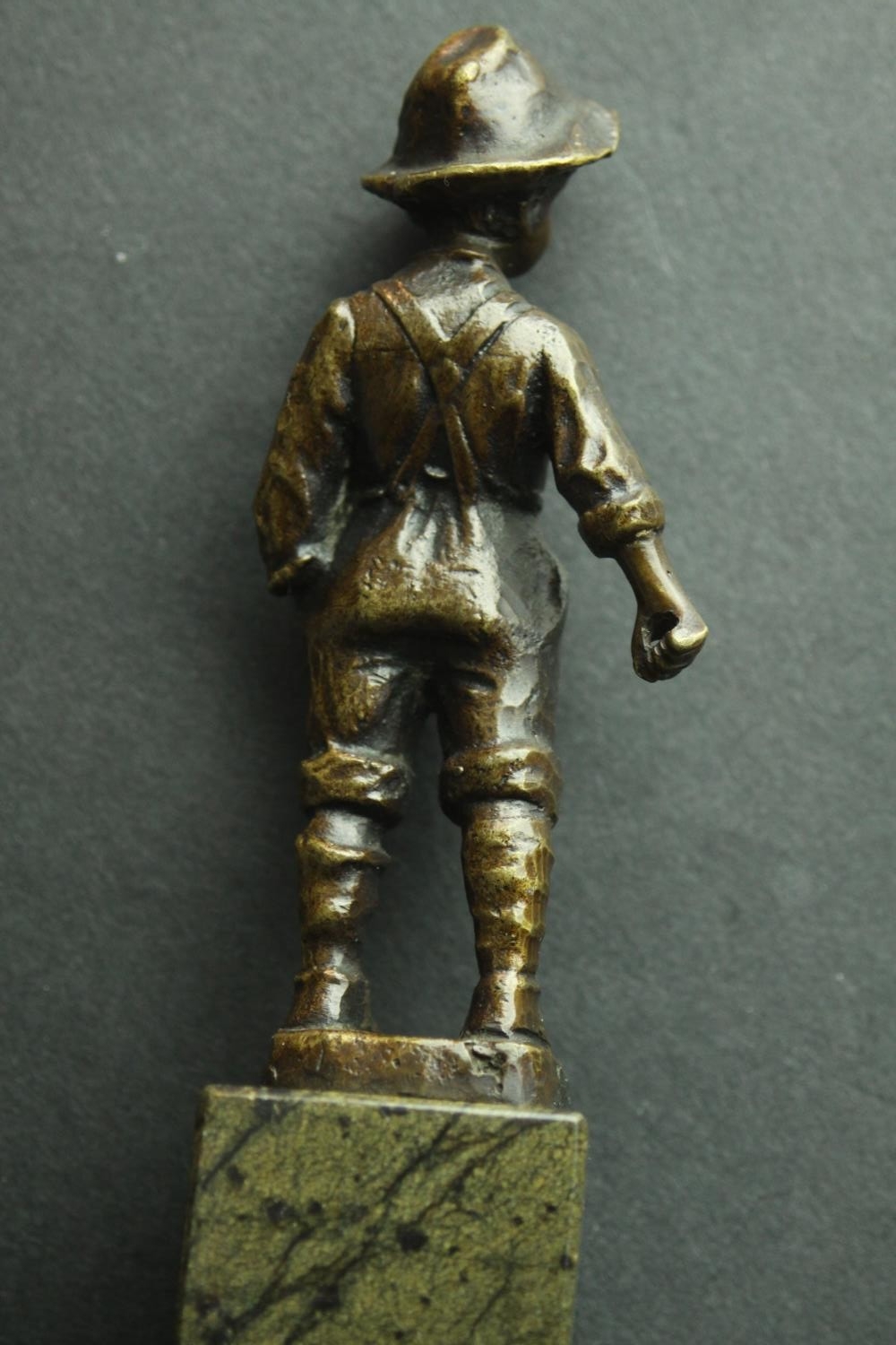 A bronze figure of an Austrian boy mounted on a serpentine marble base. H.13cm. - Image 5 of 5