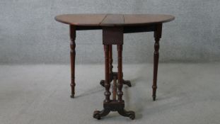 A Victorian walnut Sutherland drop leaf occasional table, with an oval top, on turned supports,