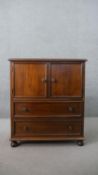 An early 20th century mahogany side cabinet, with two cupboard doors, over two long drawers, on