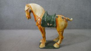 A large Tang style Chinese yellow and green glaze ceramic horse. H.80 W.90cm