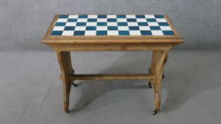 A late 19th century pine occasional table, with blue and white chequerboard tiled top, on end
