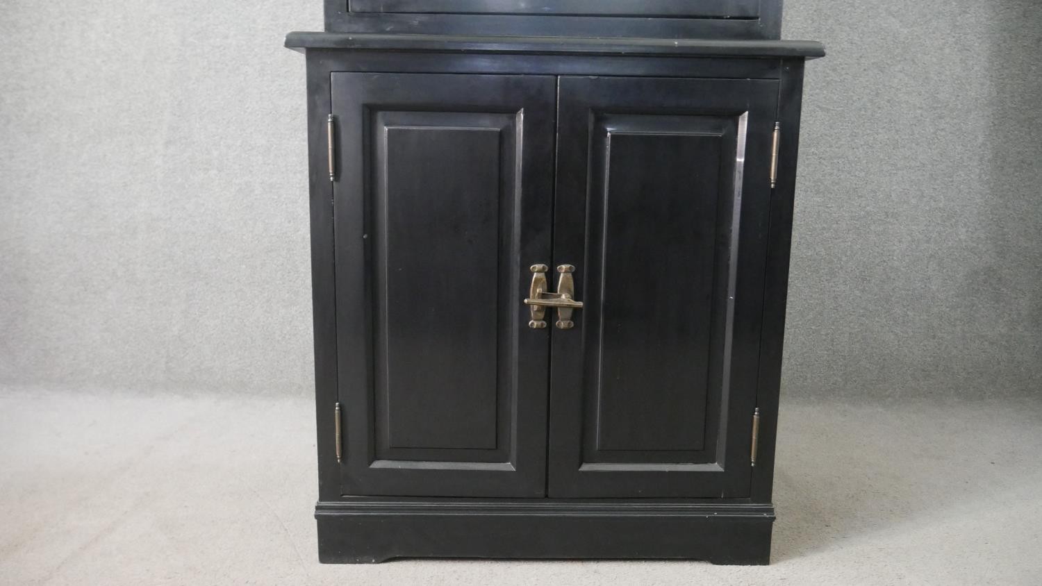 A contemporary ebonised tall cabinet, with a moulded cornice over a mirrored door, over two cupboard - Image 5 of 9