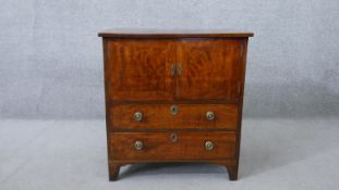 A 19th century mahogany night cabinet, with two cupboard doors over two long drawers, on shaped