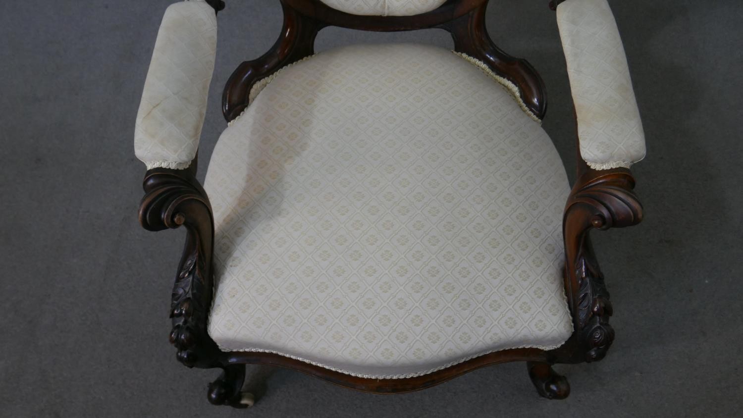 A Victorian walnut open armchair, upholstered in patterned ivory fabric, with an oval buttoned back, - Image 3 of 7