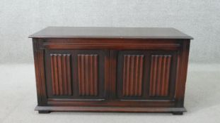 A Jacobean style oak coffer, with a rising lid, the two front panels with linen fold design in