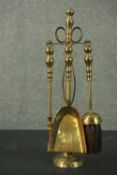 A set of brass fireside tools, on a stand, comprising tongs, a brush, a poker, and a scoop. H.43cm.