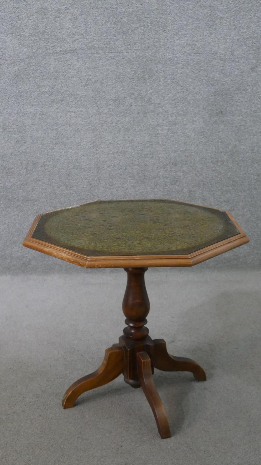 A 20th century octagonal occasional table, with a carved top, on a turned baluster stem, with four