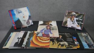 A collection of approximately fifteen vintage vinyl records, including Wings, Band on The Run,