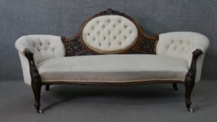 A Victorian walnut sofa, upholstered in patterned ivory fabric, with an oval buttoned back, and