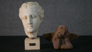 A plaster head of the Greek goddess Hygeia on a stone base along with a terracotta cherub. H.29 W.15
