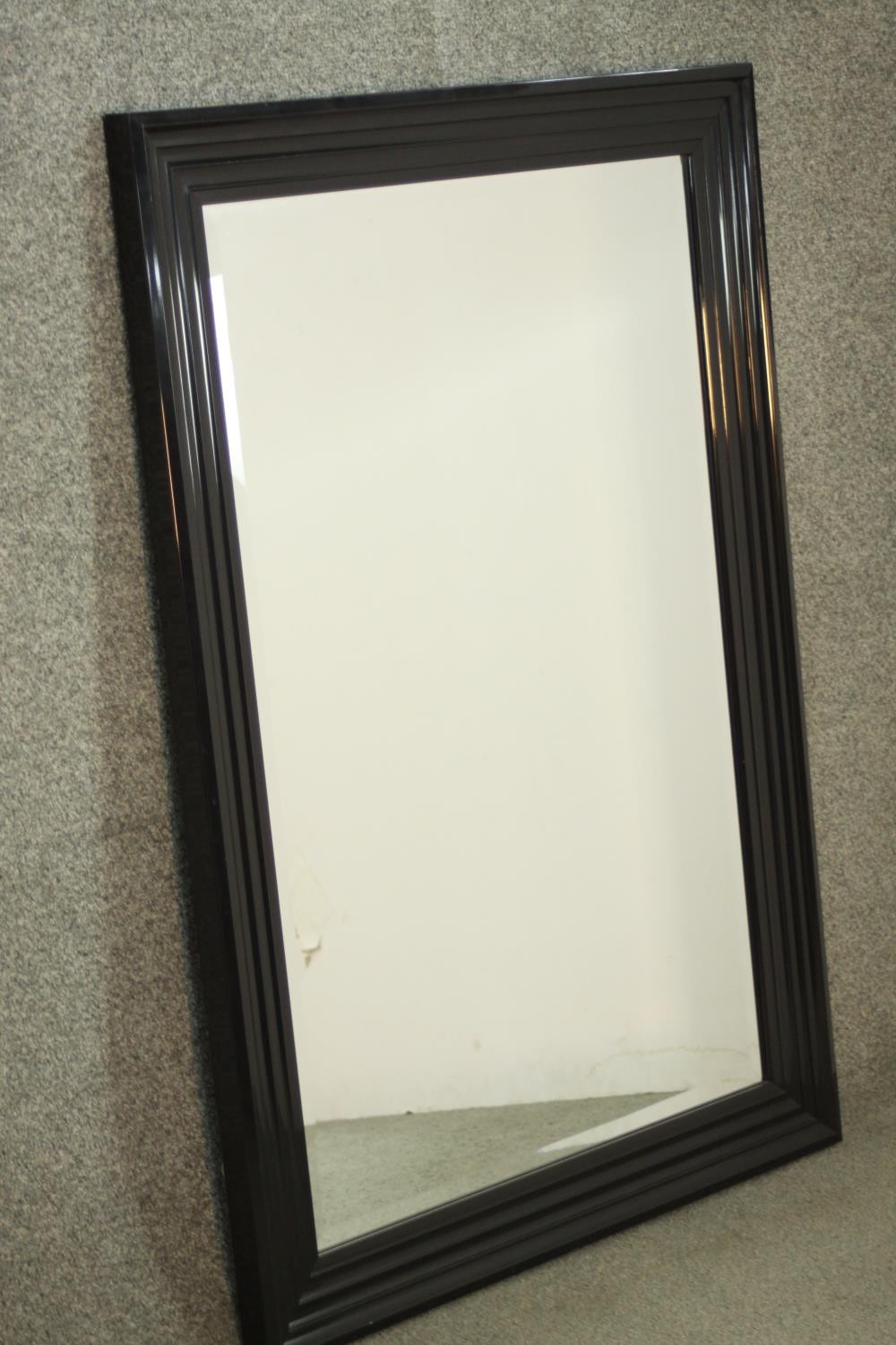 A contemporary ebonised mirror, with a rectangular mirrored plate in a moulded frame. H.107 W.76cm - Image 3 of 6