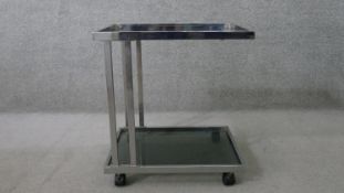 A vintage chromed metal cantilever trolley, the square section tubular frame supporting two tiers of