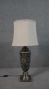 A Chinese style hand painted ceramic lamp with stylised floral design on a brushed metal base. H.