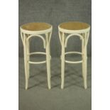 A pair of Thonet style painted bentwood bar stools, with caned seats. H.71cm.