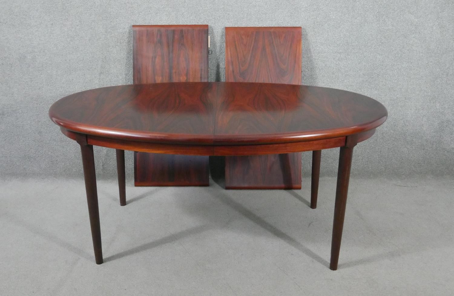 A vintage extending dining table with two extra leaves on tapering shaped supports. H.70 W.260 W.