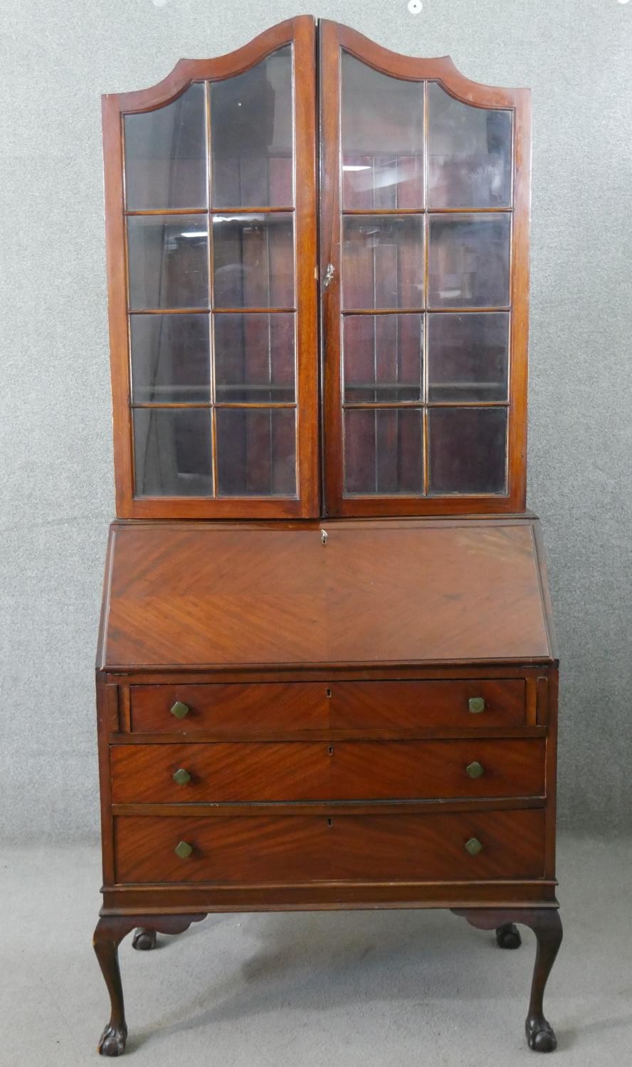 An Edwardian mahogany bureau bookcase, with two glazed doors enclosing shelves, over a quarter