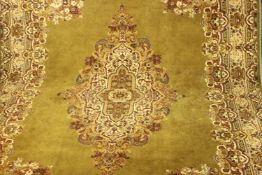 A gold ground Kirman motif woollen carpet. L.366 W.274cm.