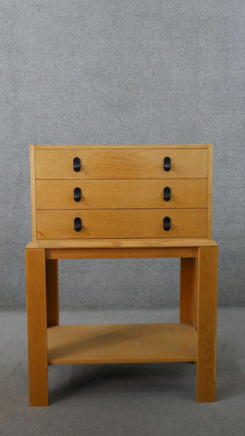 A 20th century ash chest on stand, with three long drawers over bracket legs, joined by an