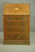 An Edwardian mahogany bureau, the fall front opening to reveal pigeonholes and two drawers, above