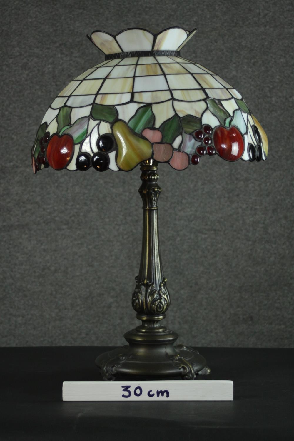 A Tiffany style table lamp, with a stained glass shade depicting fruit, the bronzed brass base - Image 2 of 10