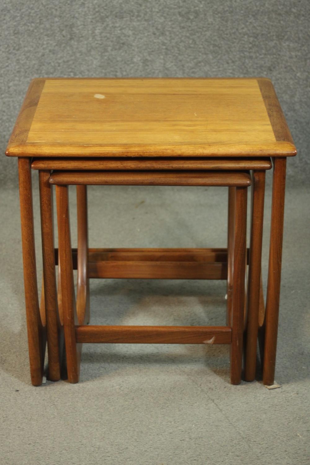 A circa 1970s nest of three teak G-Plan style tables, with crossbanded tops. H.51 W.50 D.49cm.