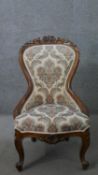 A late 19th century Continental walnut nursing chair, the waisted back with a foliate carved