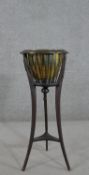 An Edwardian ebonised planter, the brass liner surrounded by curved spindles, on splayed tripod