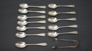 A set of twelve Victorian engraved silver tea spoons with foliate design along with a pair of Lily