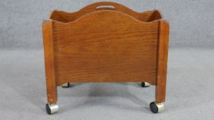 A 20th century oak Canterbury, with two sections, and brass handles, on castors. H.43 W.46 D.32cm