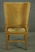 An oak Orkney chair, 20th century, with a woven straw back and drop-in cord seat, scrolled arms on