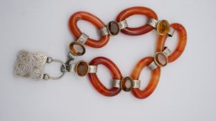 A Scottish carnelian chain link bracelet with engraved white metal links set with oval mixed cut