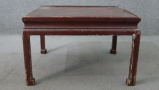 A 19th century Chinese red lacquered coffee table, of square form, the top decorated with a