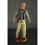 A Franklin Heirloom John Wayne doll and stand, porcelain and cloth, 1990. H.54cm.