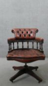 A Victorian style captain's swivel desk chair, with a brown leather buttoned back and seat, and a