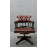 A Victorian style captain's swivel desk chair, with a brown leather buttoned back and seat, and a