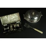 A silver plate cased cruet set along with a muffin fork and muffin warmer with scrolling form