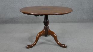 A 19th century walnut circular occasional table, with a turned baluster stem, on tripod supports