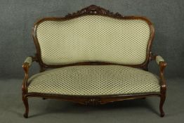 A late 19th century French walnut canape sofa, with a carved scrolling top rail, upholstered to