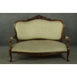 A late 19th century French walnut canape sofa, with a carved scrolling top rail, upholstered to