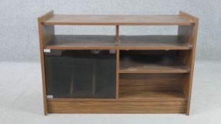 A circa 1970s walnut record cabinet, with an arrangement of shelves and recesses, and a smoked glass