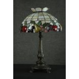 A Tiffany style table lamp, with a stained glass shade depicting fruit, the bronzed brass base