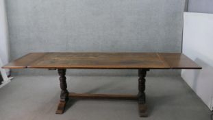 A 19th century oak extending refectory dining table in the antique style, the plank top with cleated