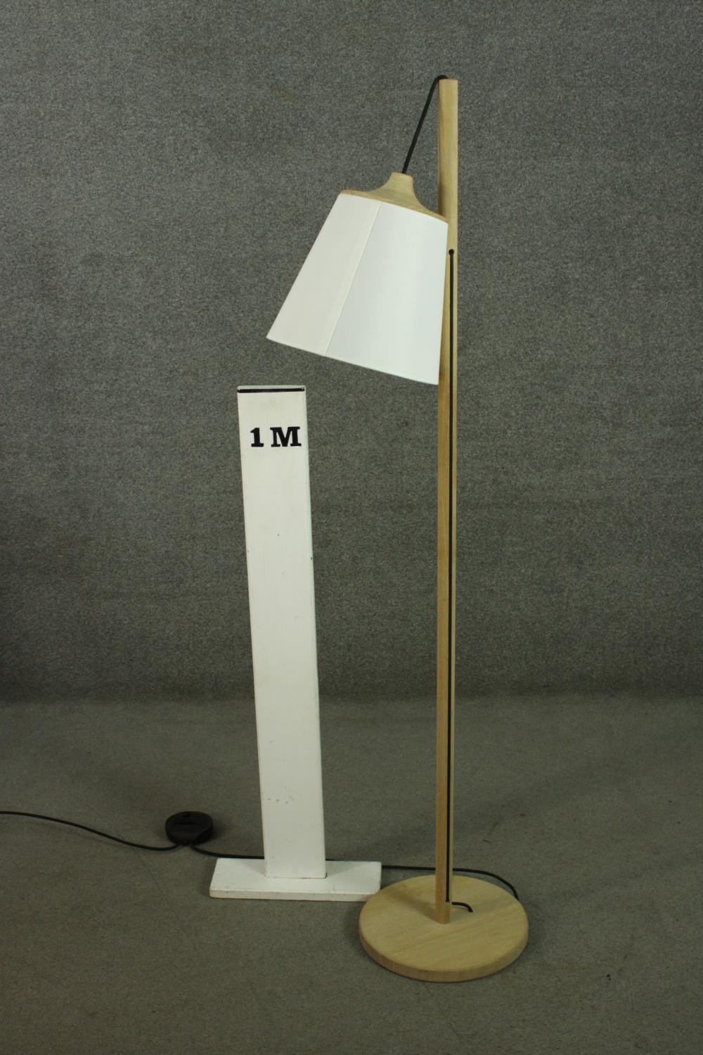 A contemporary light oak standard lamp, the white shade hanging from a cylindrical stem, on a - Image 2 of 7