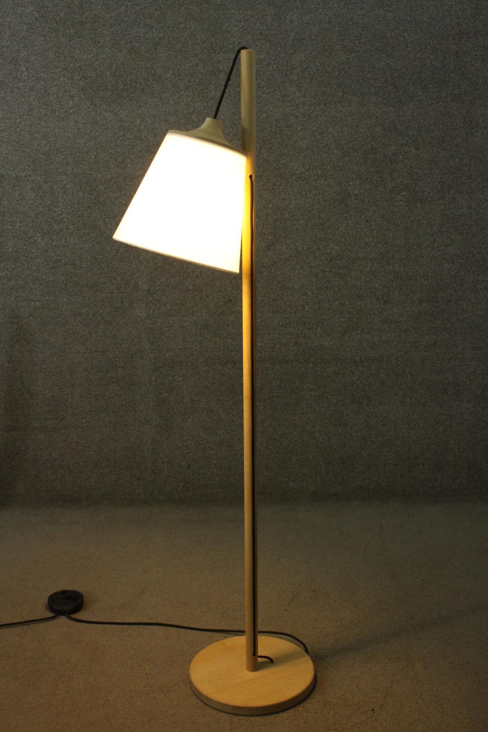 A contemporary light oak standard lamp, the white shade hanging from a cylindrical stem, on a - Image 3 of 7